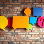 Colorful speech bubbles and question mark on a brick wall background.